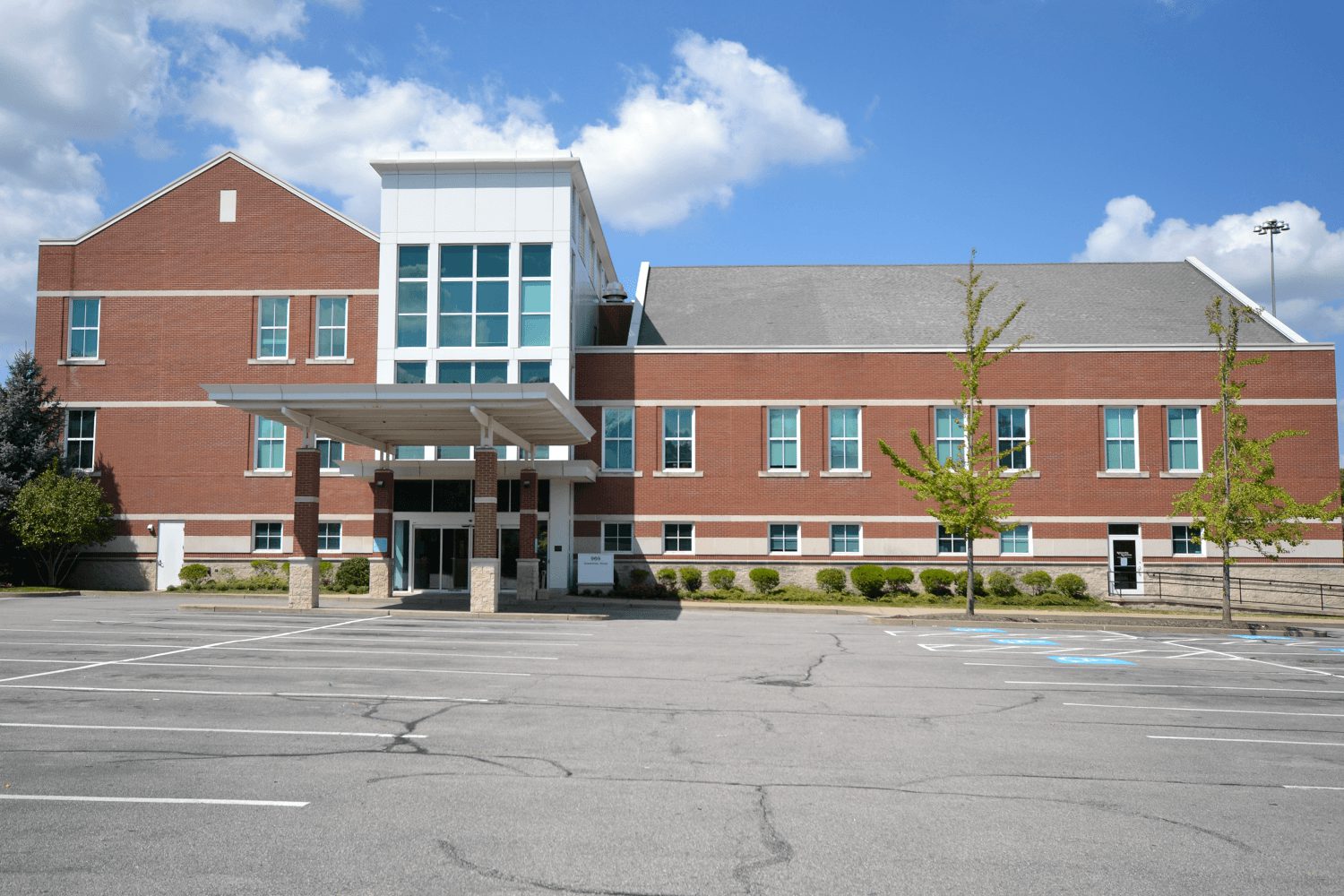Exterior of the medical care facility, with a large parking lot