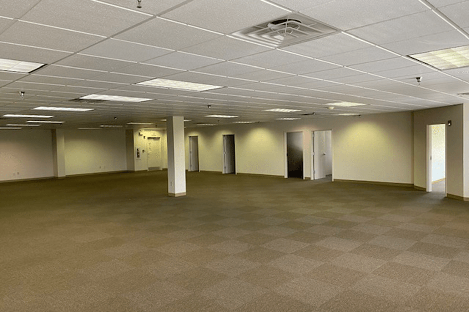 large empty room with tan carpet and white walls