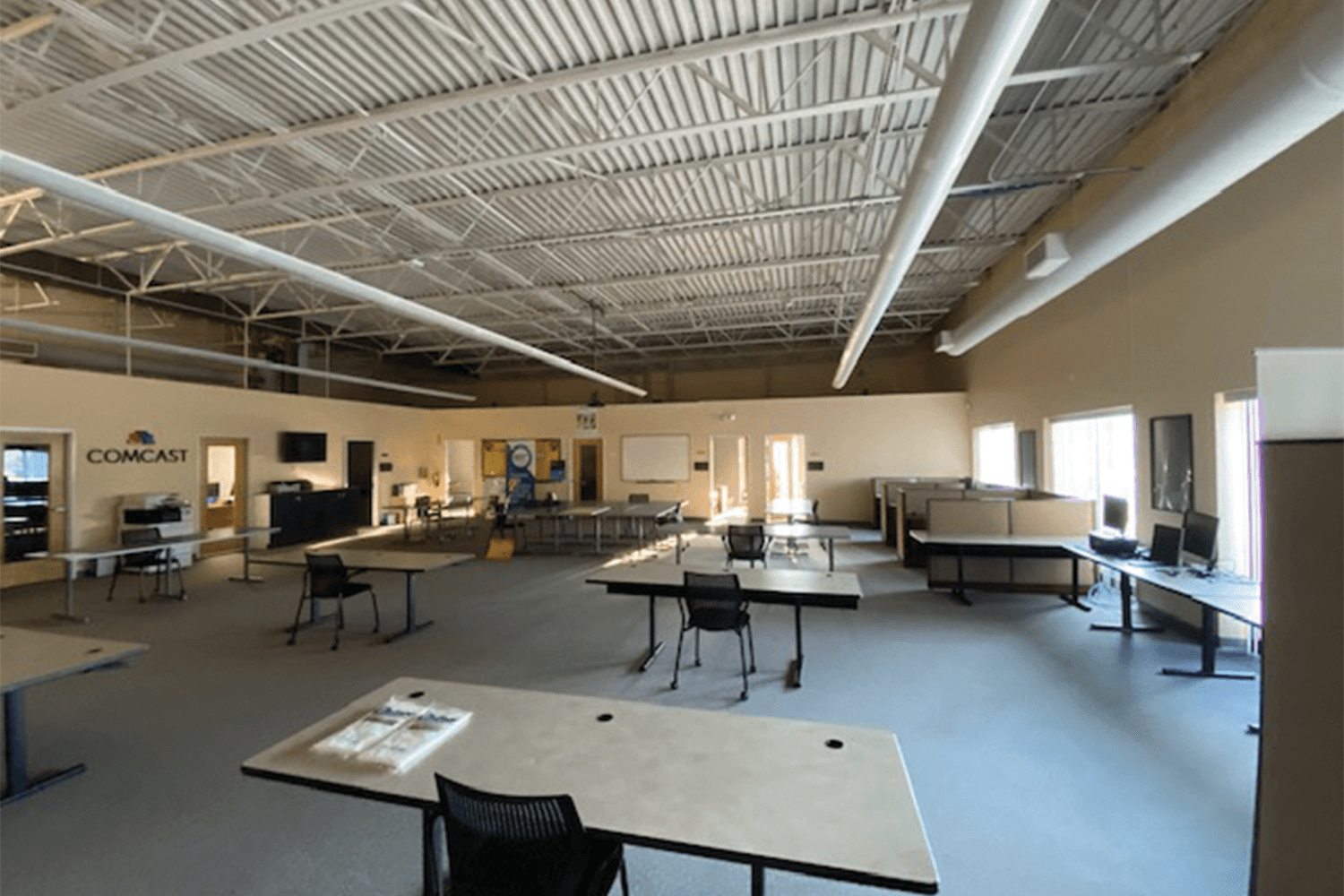 large open office area with desks and a high ceiling