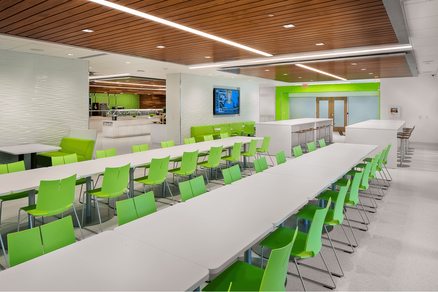 open workspace with bright white tables and green chairs