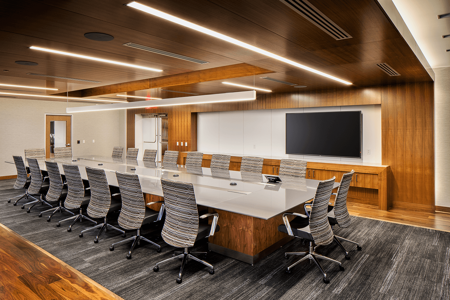 conference room with gray striped chairs and carpet, and wood accent features