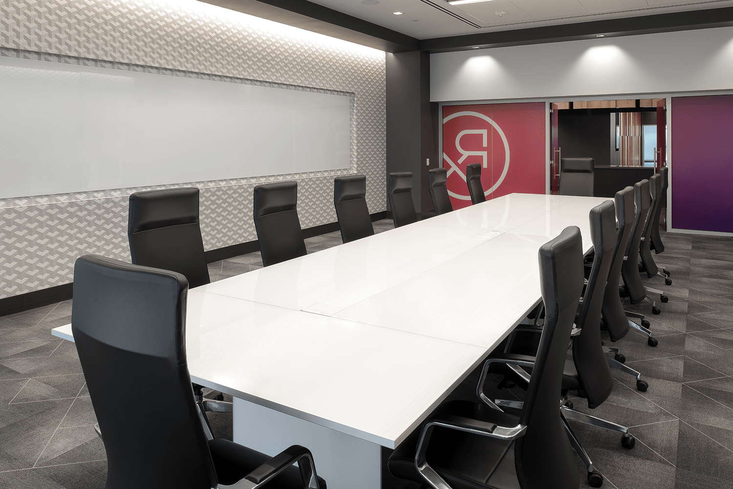 conference room with modern aesthetic and large table with desk chairs