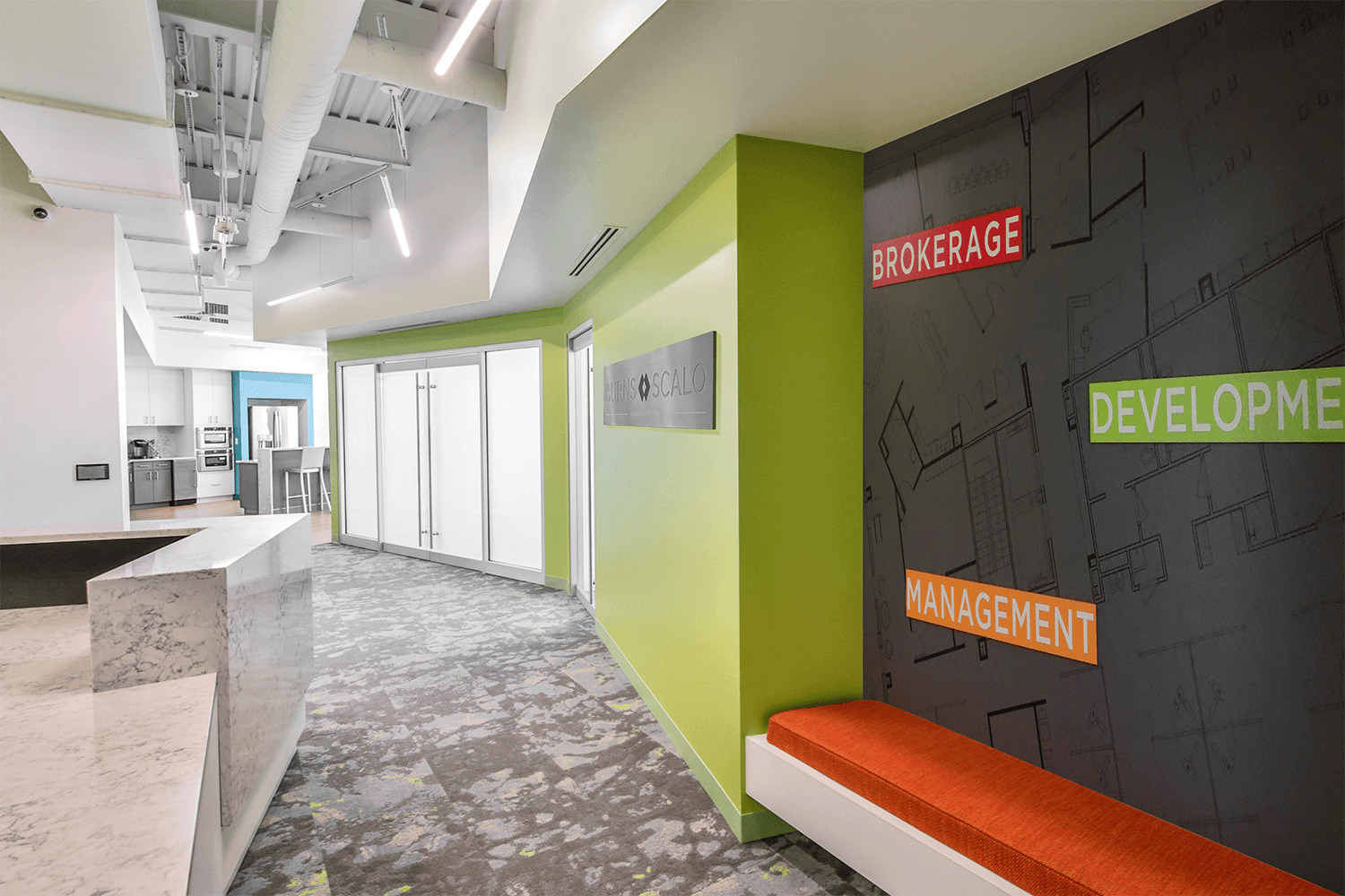 concierge area with a desk, a bright green hallway, and wall graphics