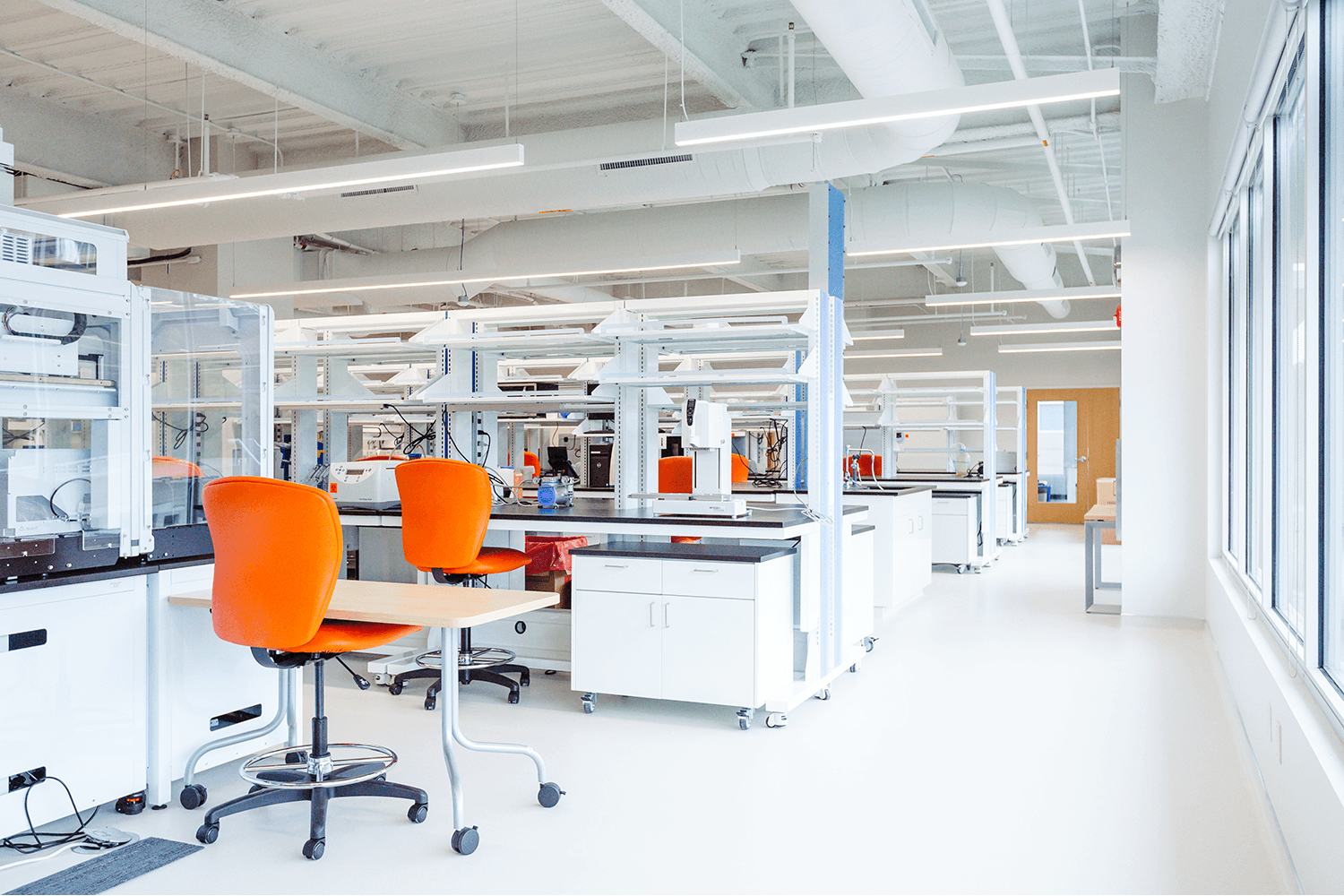 bright white lab space with lab equipment and orange chairs
