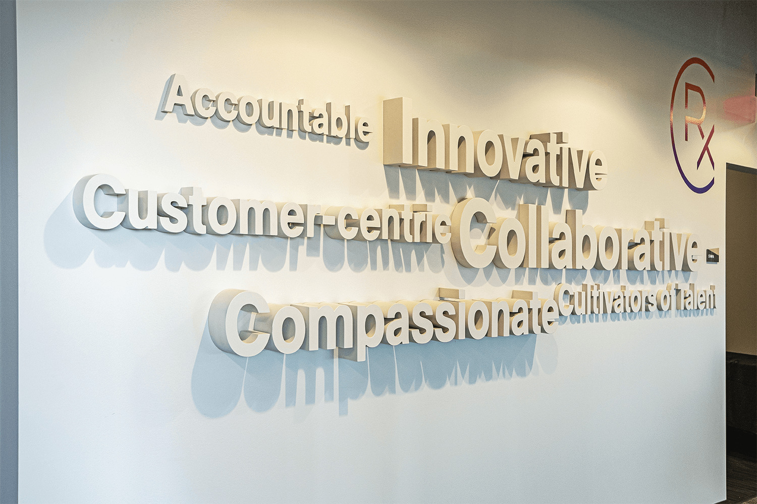 3D decorative word cloud built on a wall, reads: Accountable, Innovative, Customer-centric, Collaborative, Compassionate, Cultivators of Talent