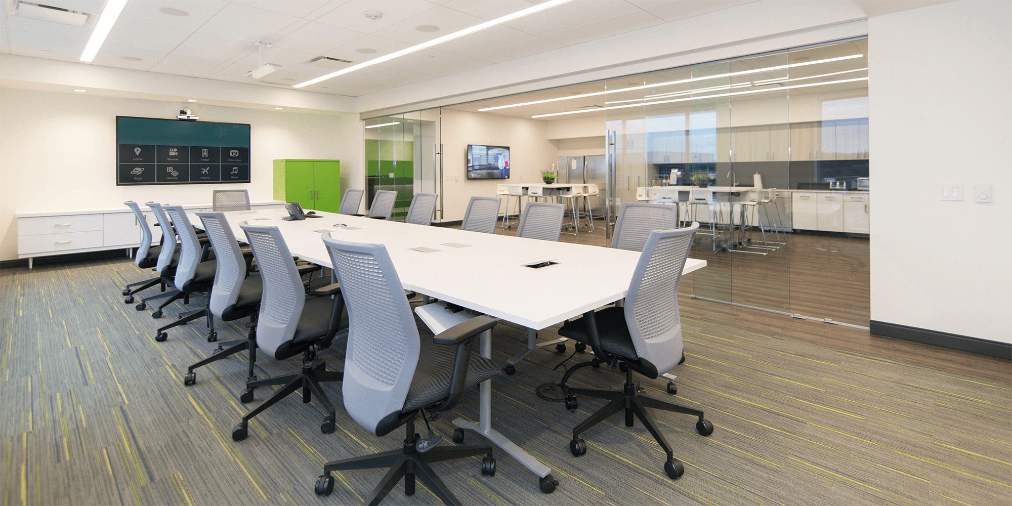 large conference room with a TV display, and a large table with dresk chairs