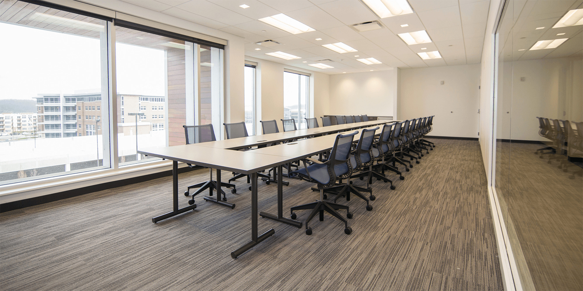 large conference room with a long table and a lot fo chairs, large floor-to-ceiling windows