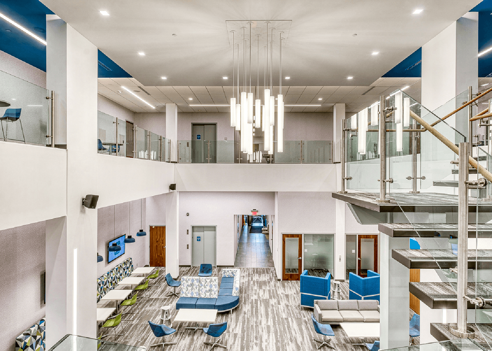 two-story Dollar Bank space with bright white walls and blue furniture
