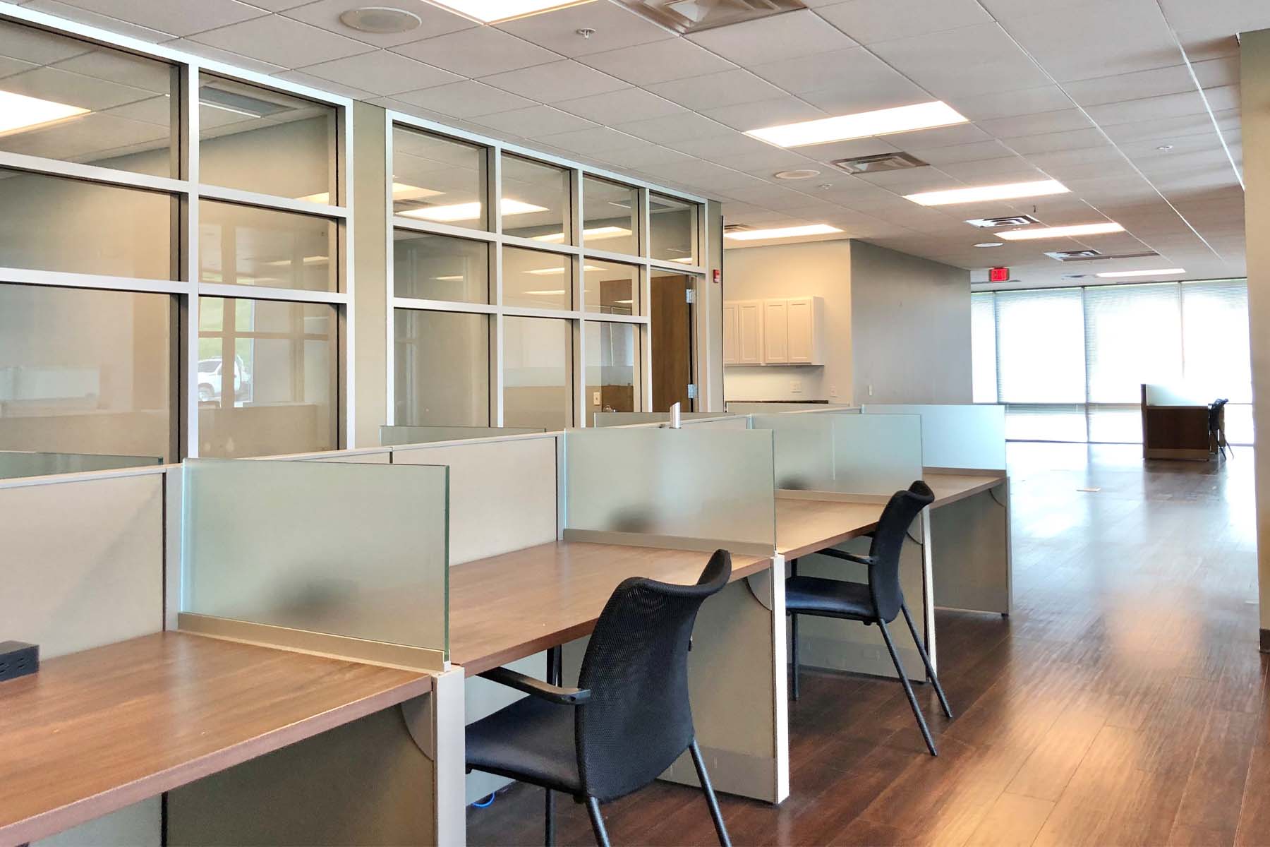 Separated office desks with chairs and open floorplan