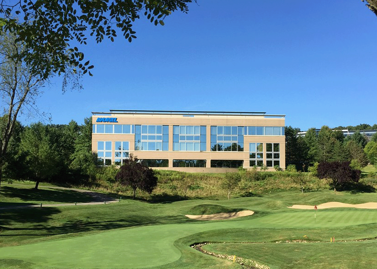 building exterior photo with a golf course in front