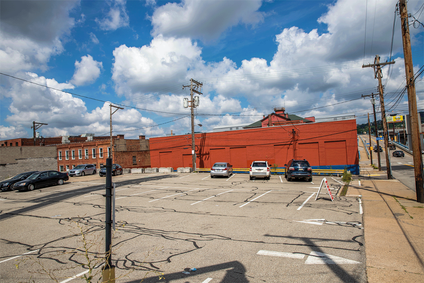 large empty parking lot with oranger brick building behind