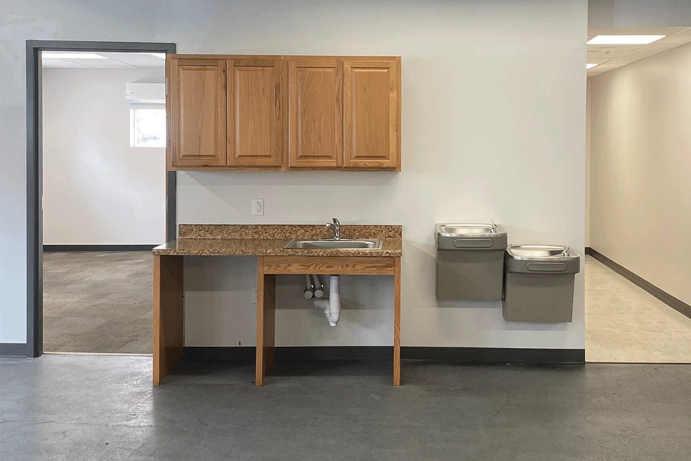 sink and water fountain with cabinets above