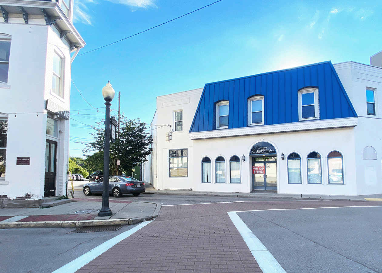 two story white building with a blue auning